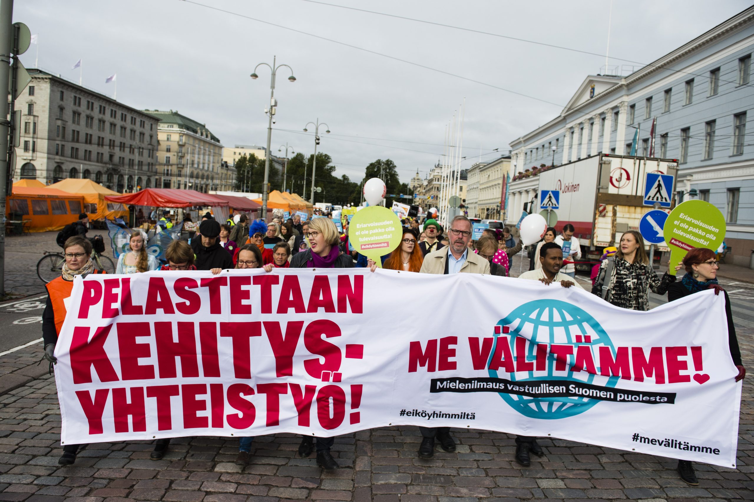 Mielenosoittajia Pelastetaan kehitysyhteistyö -bannerin takana Helsingin keskustassa.