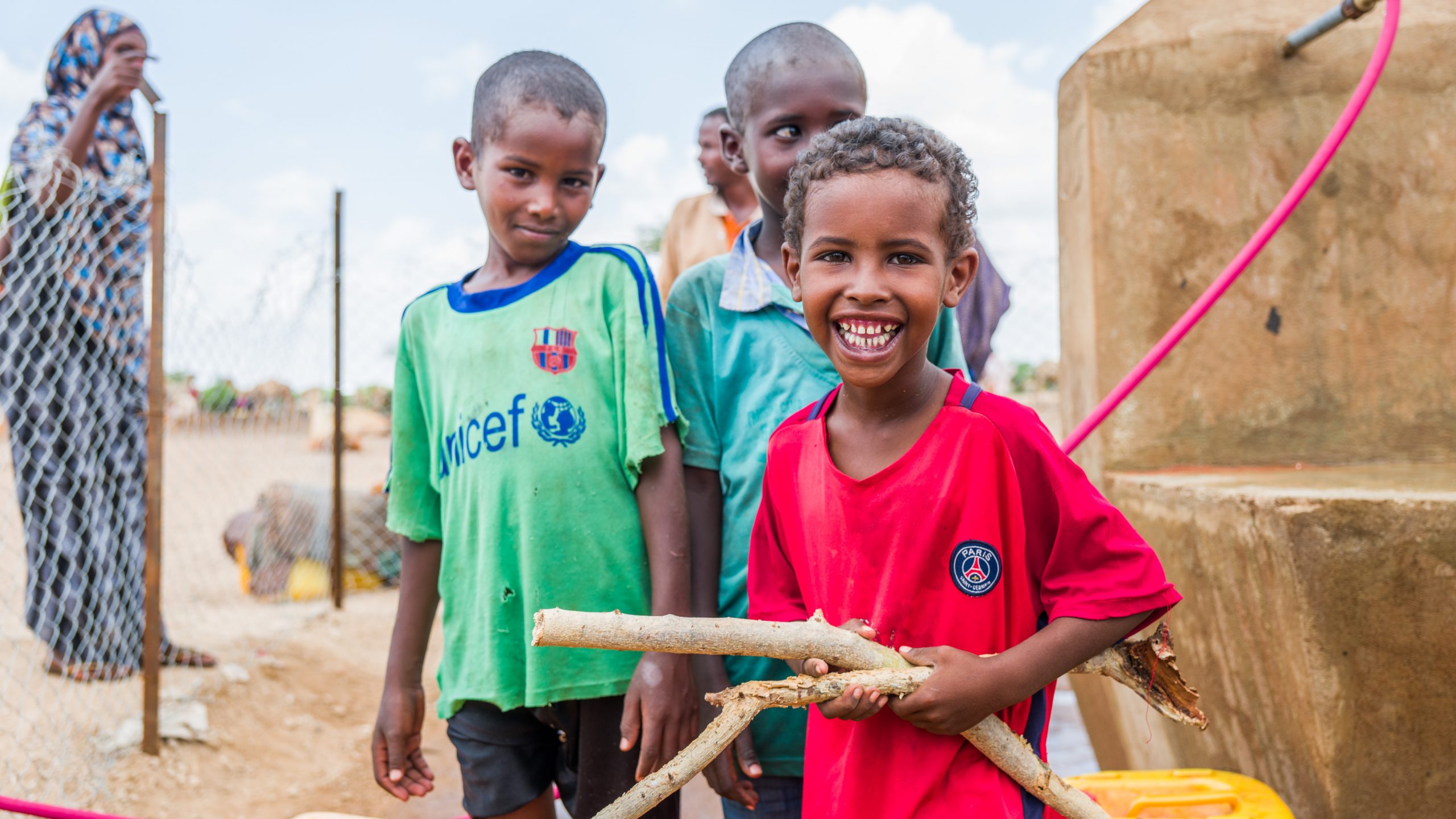 kolme iloista somalipoikaa kaivon luona