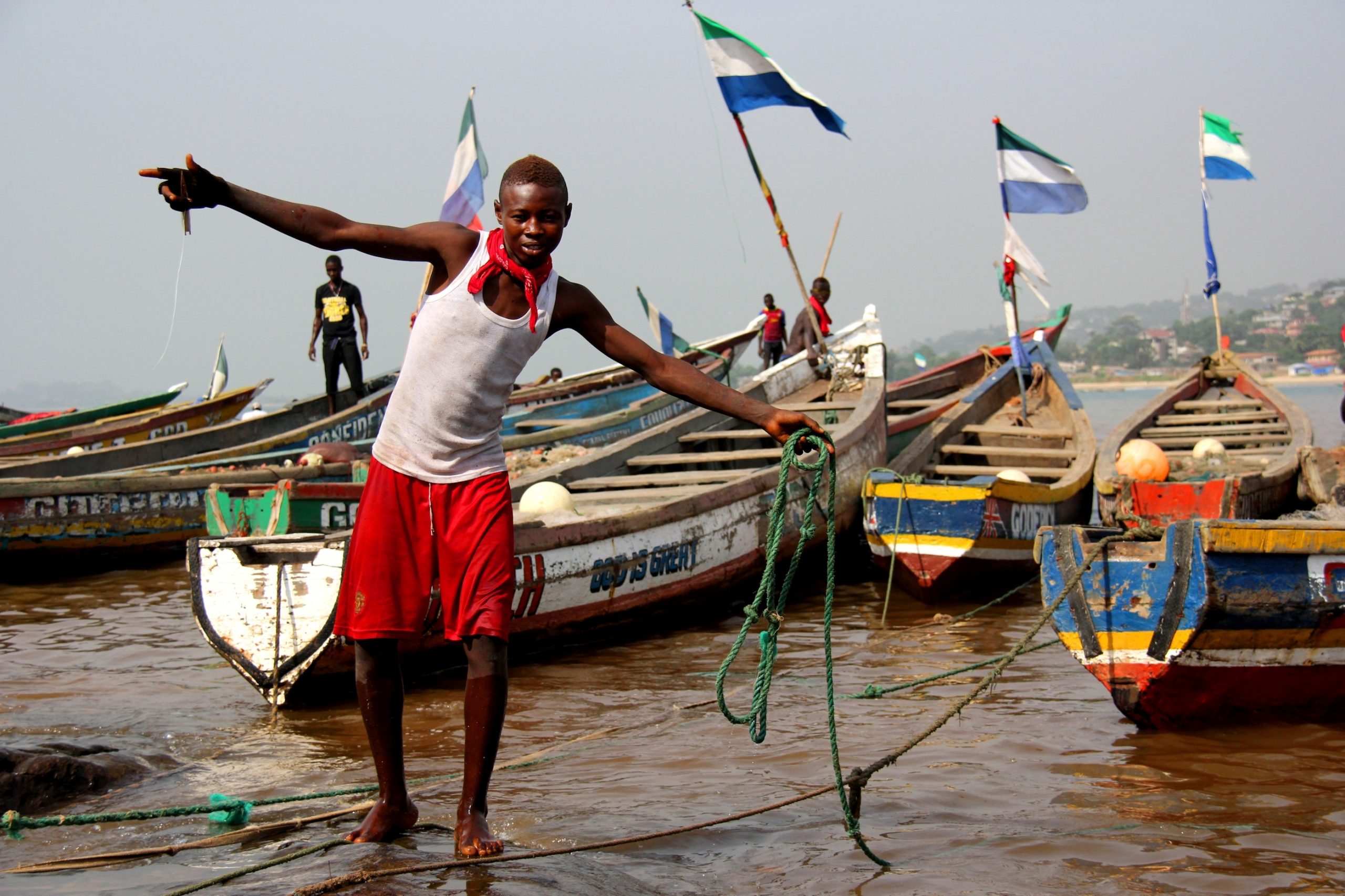 Sierraleonelainen poika rannalla kalastusveneiden keskellä.