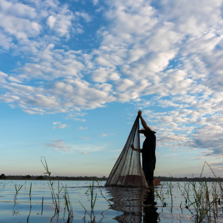 Kalastaja meren äärellä aamulla.