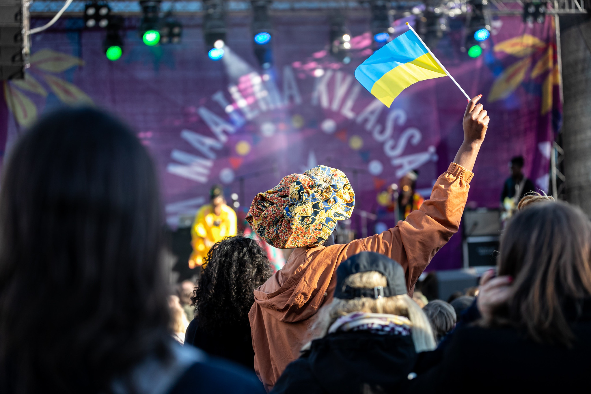 World Village Festival stage pictured from the audience. An audience member waving the Ukrainian flag.