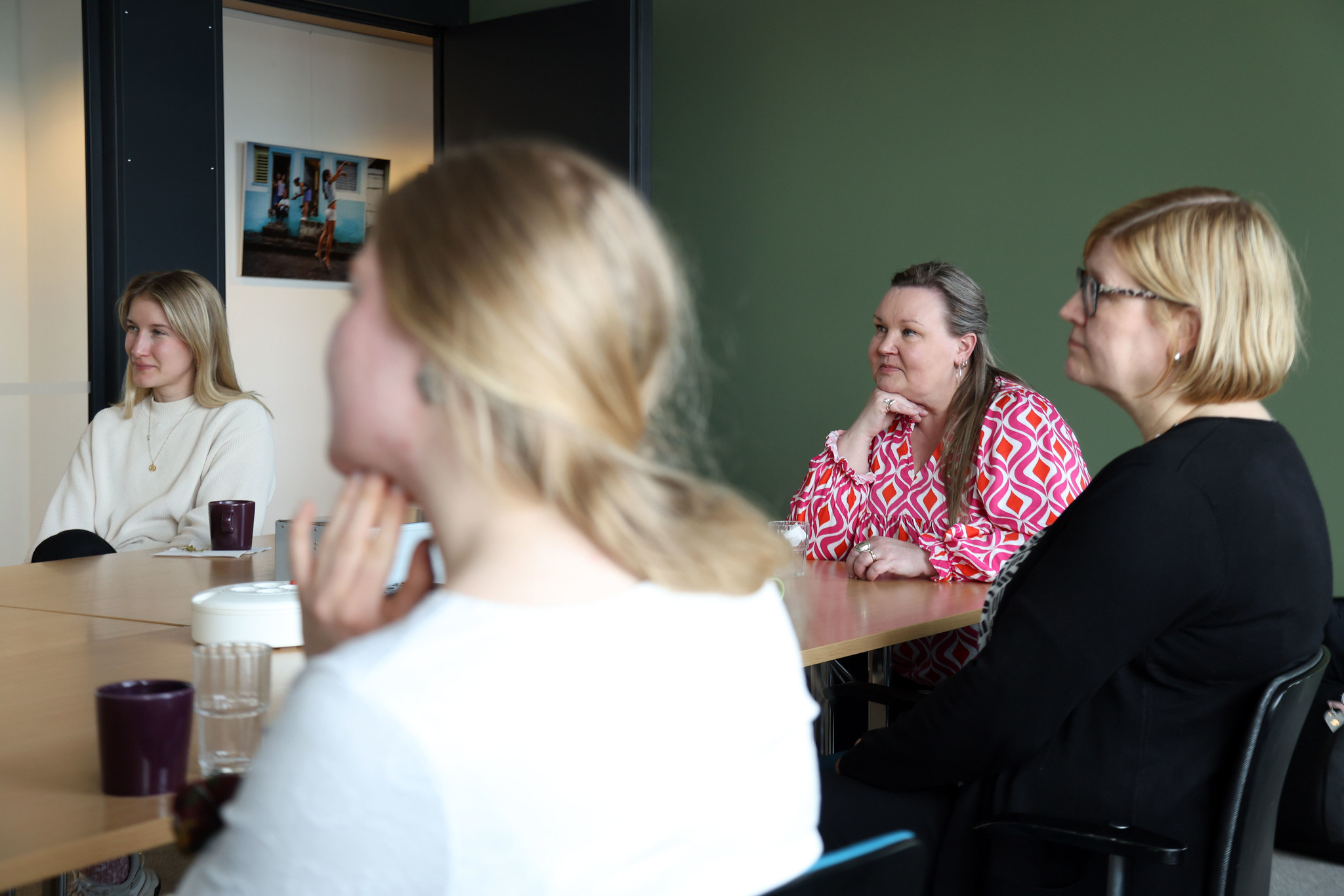 People sitting at a conference room table.