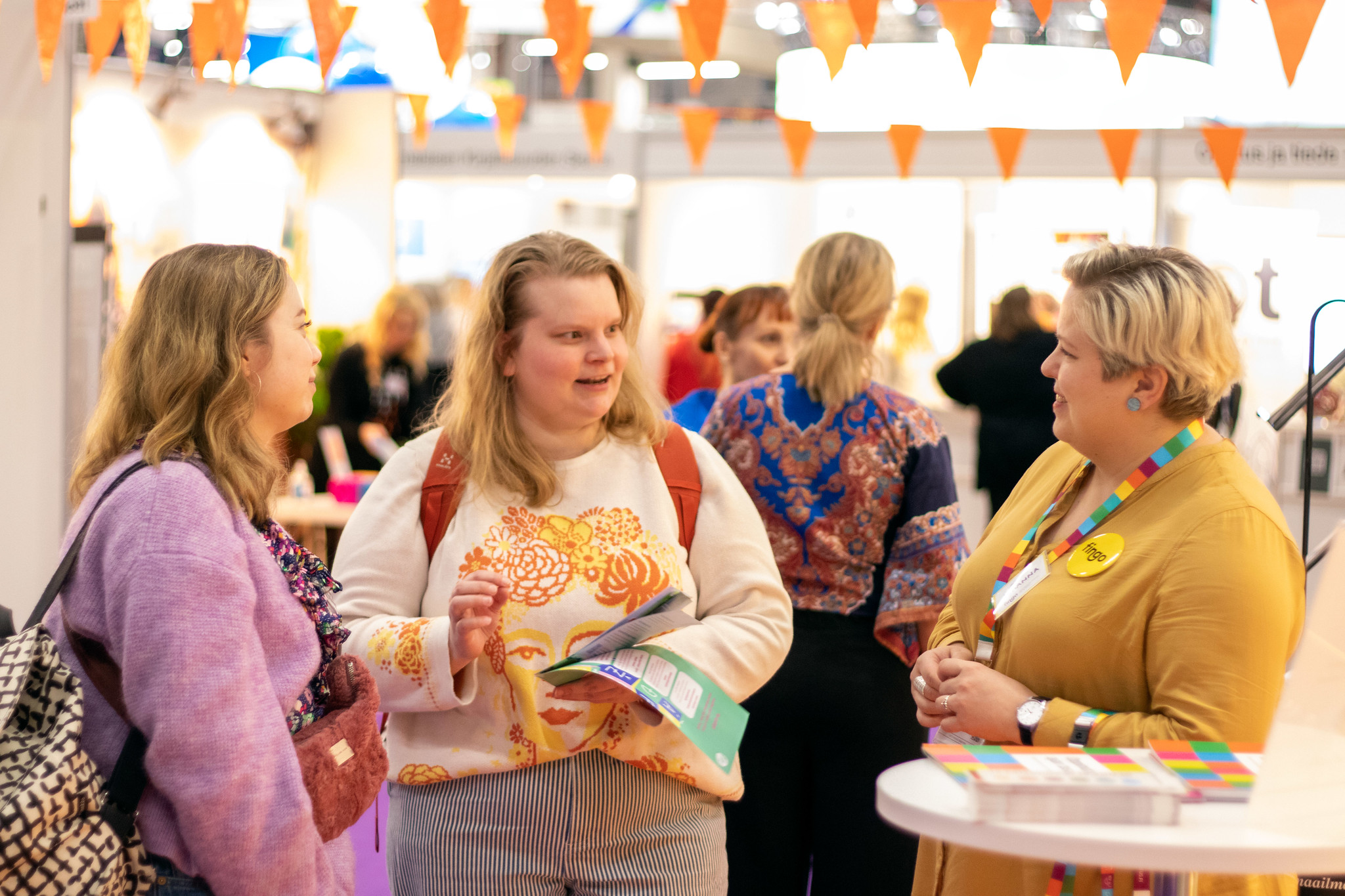 Three people having a discussion at a fair.